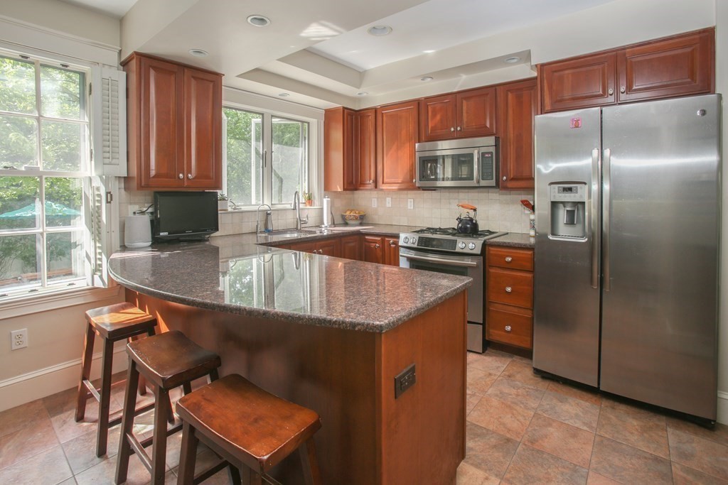5 Braeburn Road Newton, MA 02466 - Photo 7 of 19 a kitchen with stainless steel appliances granite countertop a refrigerator a sink a stove and island