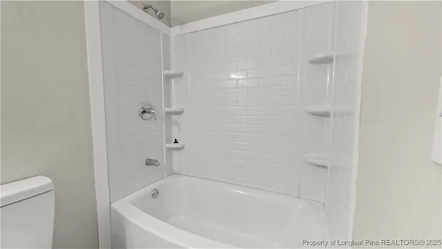 a white bath tub sitting next to a toilet