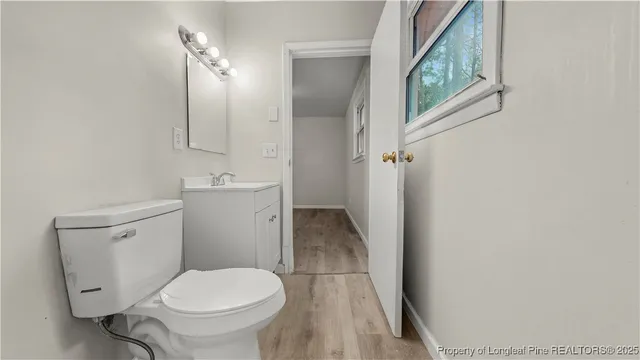 a white toilet sitting next to a bathroom sink and a mirror