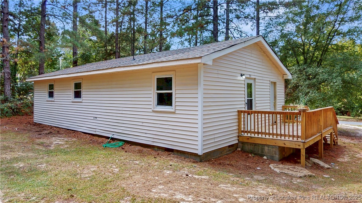 164 Happy Valley Road West End, NC 27376 - Photo 15 of 17 a view of a wooden deck with a bench and trees