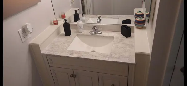 a bathroom with a granite countertop sink and a mirror