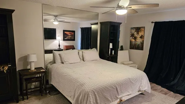a bedroom with a bed and a flat tv screen on dresser