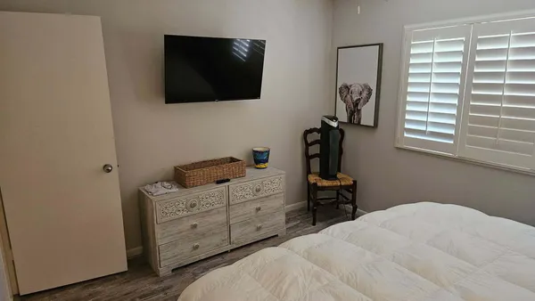 a bedroom with a bed and a flat tv screen on the dresser