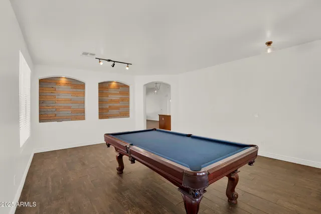 a room with pool table and windows