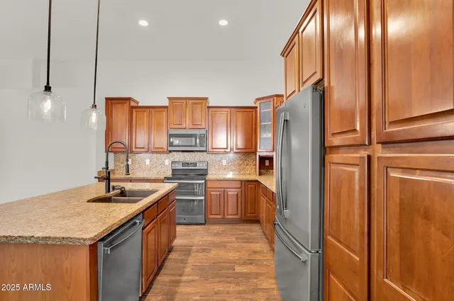 a kitchen with stainless steel appliances granite countertop a refrigerator and a sink
