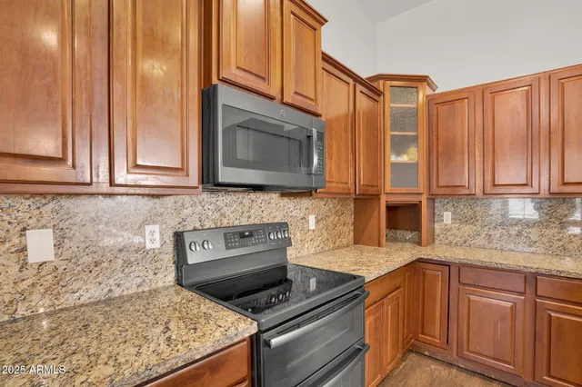 a kitchen with stainless steel appliances granite countertop a stove a sink and a microwave