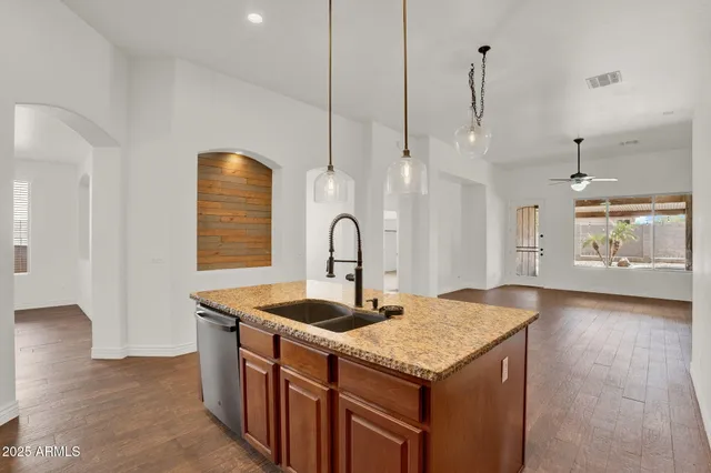 a kitchen with granite countertop a sink and a refrigerator