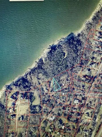 a view of an empty room with wooden floor fireplace and a window