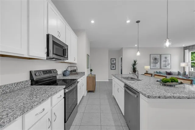 a kitchen with granite countertop stainless steel appliances a stove sink and microwave