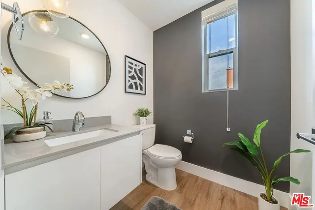a bathroom with a granite countertop toilet sink and mirror