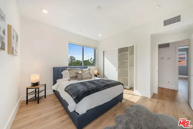 a spacious bedroom with a bed and a table in it