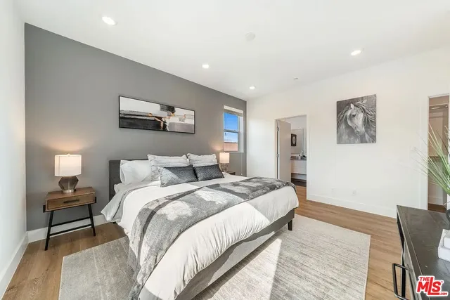 a spacious bedroom with a bed and a painting on the wall