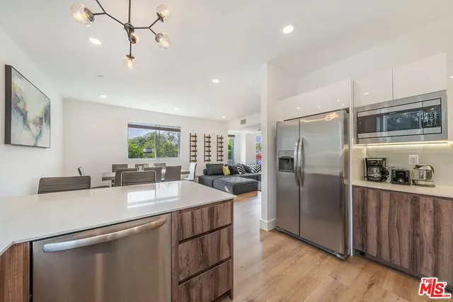 a kitchen with kitchen island a counter top space stainless steel appliances and cabinets