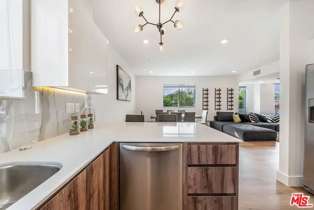 a kitchen with kitchen island a sink appliances and a counter top space