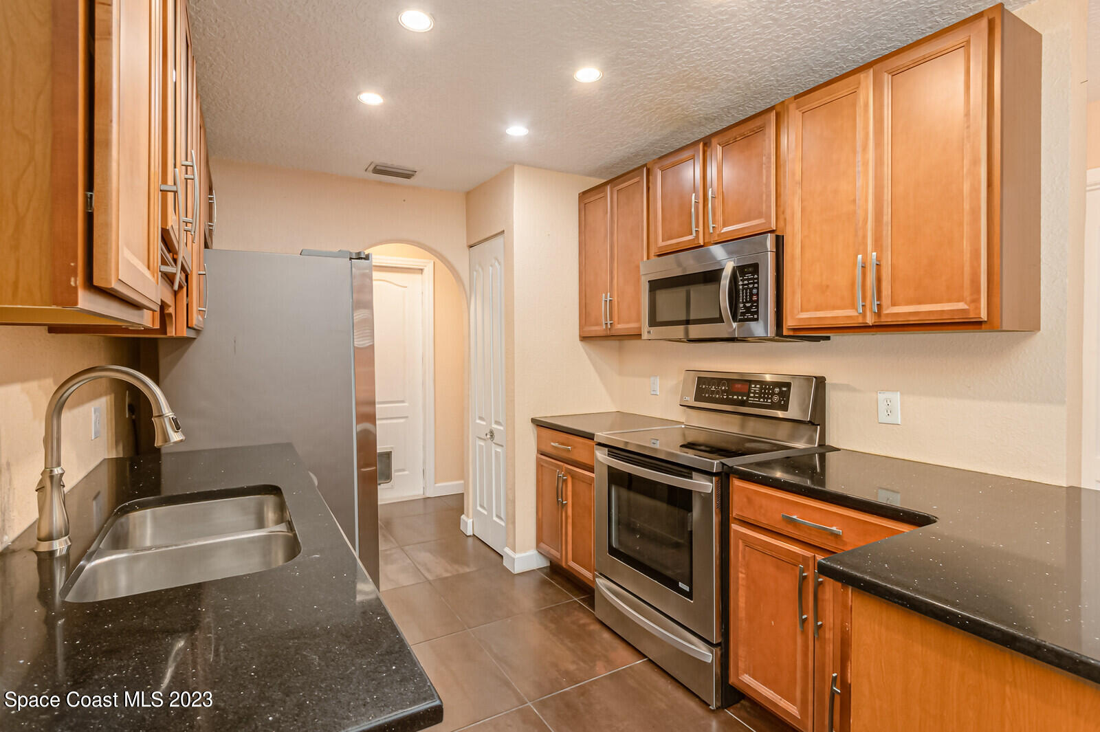 2567 Wright Avenue Melbourne, FL 32935 - Photo 7 of 36 a kitchen with stainless steel appliances granite countertop a stove a sink and a microwave
