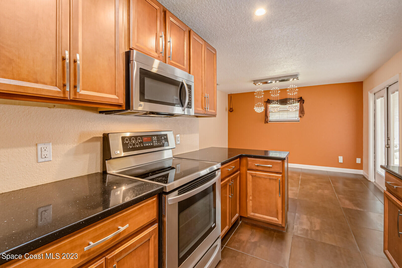 2567 Wright Avenue Melbourne, FL 32935 - Photo 9 of 36 a kitchen with stainless steel appliances granite countertop a stove a sink and a microwave