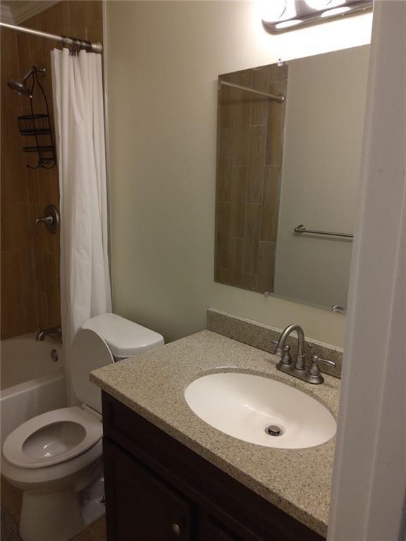 405 Fairburn Road Southwest, Unit 21 Atlanta, GA 30331 - Photo 11 of 16 a bathroom with a granite countertop sink toilet and shower