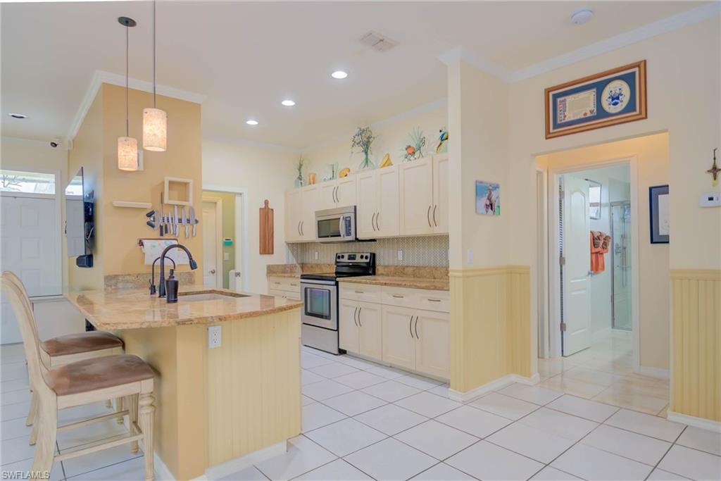 18370 Tulip Road Fort Myers, FL 33967 - Photo 8 of 30 a kitchen with white cabinets and refrigerator