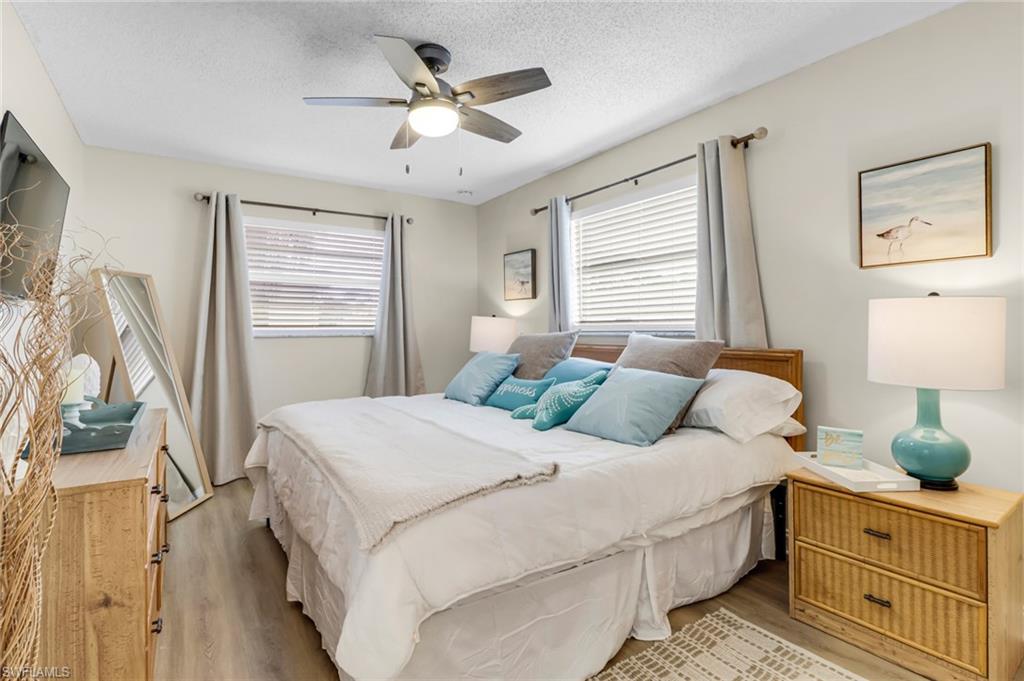 3325 Airport Road North, Unit G5 Naples, FL 34105 - Photo 5 of 8 Bedroom with light wood-type flooring, a ceiling fan, and a textured ceiling