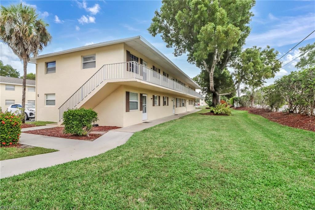 3325 Airport Road North, Unit G5 Naples, FL 34105 - Photo 8 of 8 Back of property with a lawn, stucco siding, and a balcony