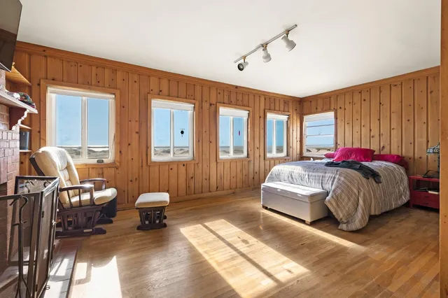 a spacious bedroom with a bed a mirror and a window