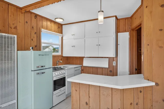 a kitchen with cabinets and white stainless steel appliances