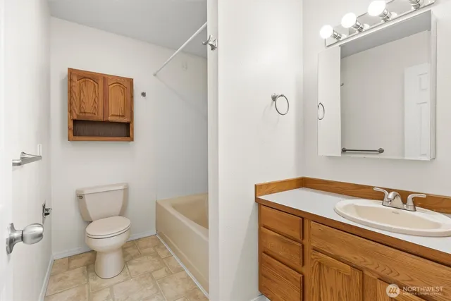 a bathroom with a granite countertop sink a toilet and a mirror