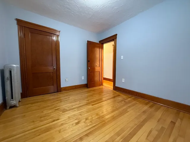 a view of an empty room with closet and a window