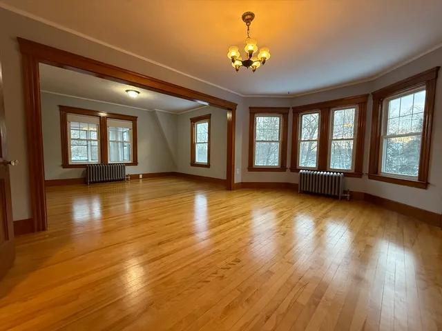 a view of an room with wooden floor and chandelier