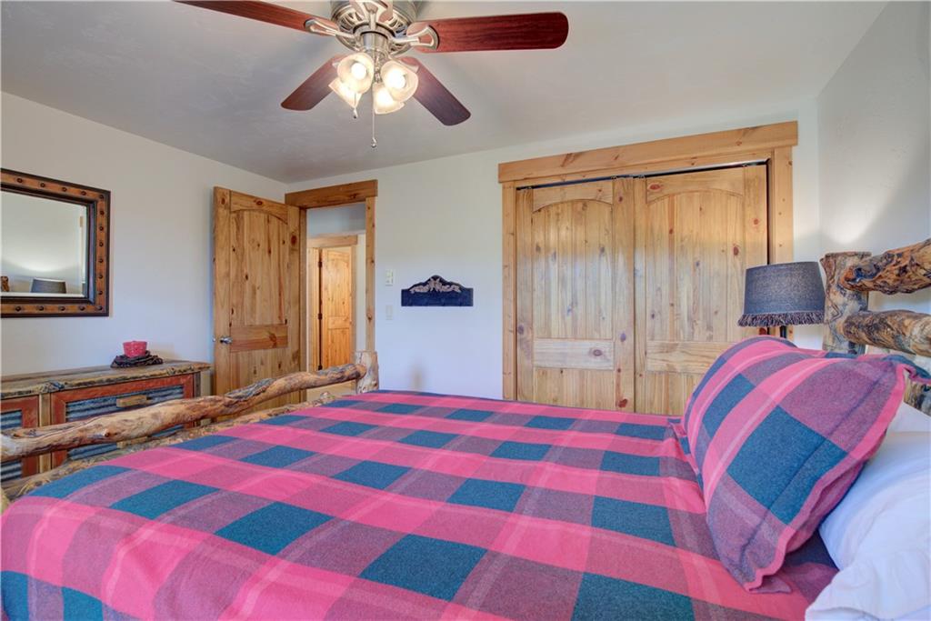 142 Poplar Circle Silverthorne, CO 80498 - Photo 22 of 35 a bedroom with a bed and a chandelier