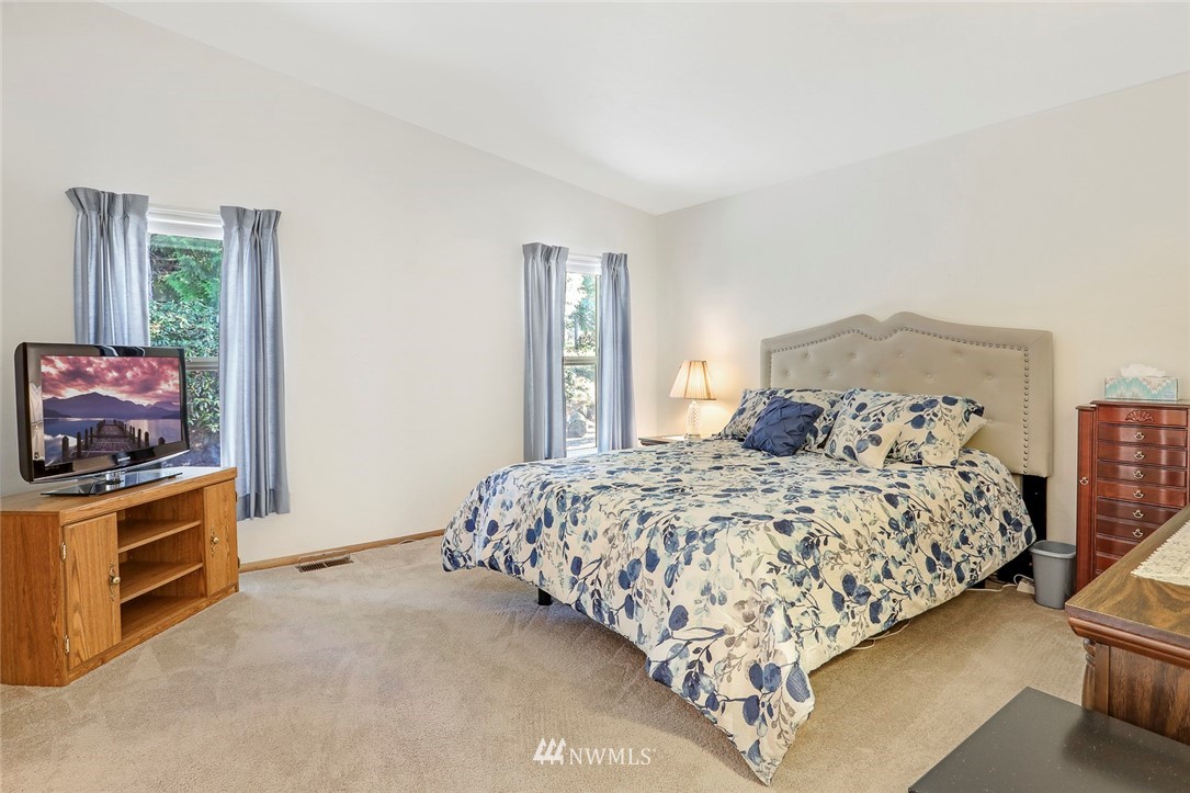 24111 8th Place West Bothell, WA 98021 - Photo 20 of 34 a bed sitting in a bedroom next to a window with tv