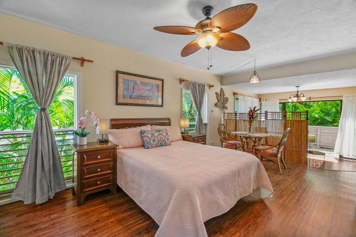 4480 Ka Haku Road, Unit 105 Princeville, HI 96722 - Photo 1 of 25 a bedroom with a bed a chandelier and a large window