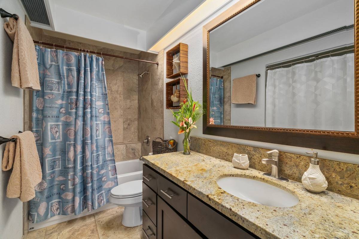 4480 Ka Haku Road, Unit 105 Princeville, HI 96722 - Photo 11 of 25 a bathroom with a granite countertop sink and a mirror