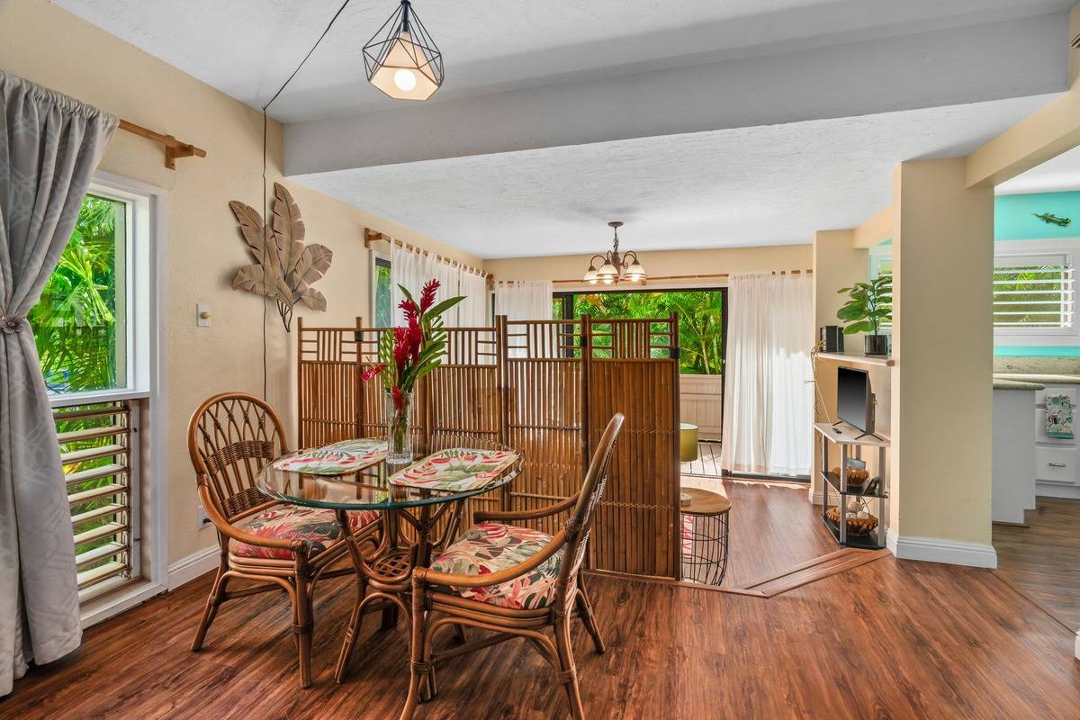 4480 Ka Haku Road, Unit 105 Princeville, HI 96722 - Photo 12 of 25 a dining room with furniture a chandelier and wooden floor