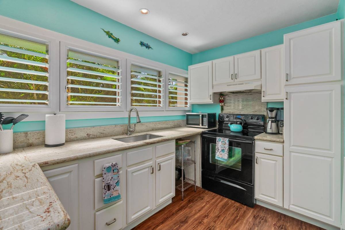 4480 Ka Haku Road, Unit 105 Princeville, HI 96722 - Photo 15 of 25 a kitchen with granite countertop a sink stainless steel appliances and cabinets
