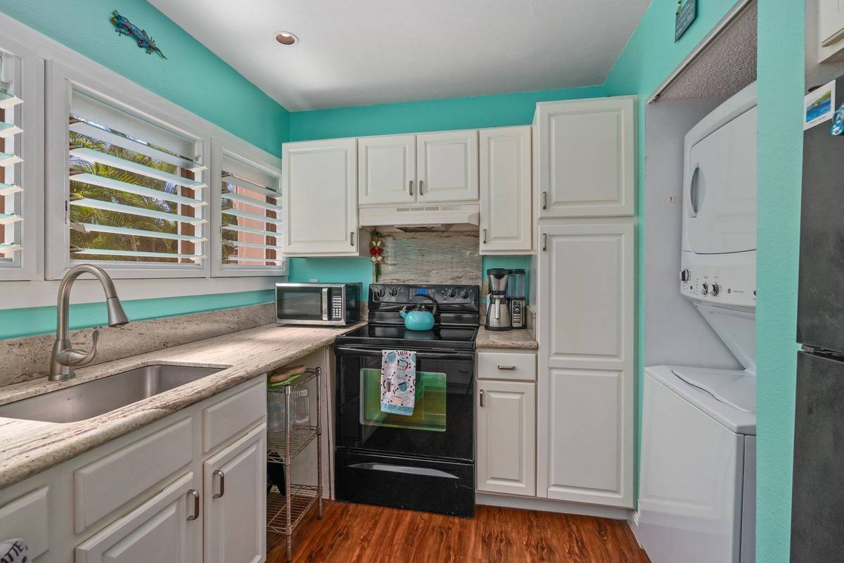 4480 Ka Haku Road, Unit 105 Princeville, HI 96722 - Photo 16 of 25 a kitchen with granite countertop a refrigerator and a sink