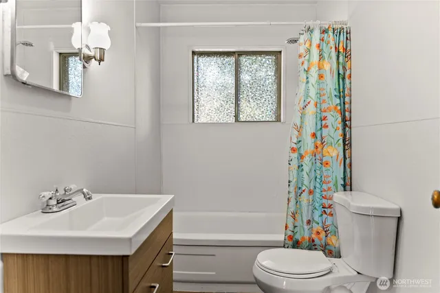 a bathroom with a sink a toilet and shower curtain