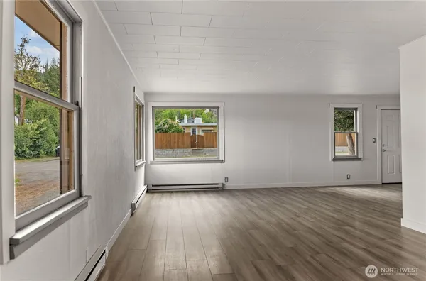 an empty room with windows and wooden floor