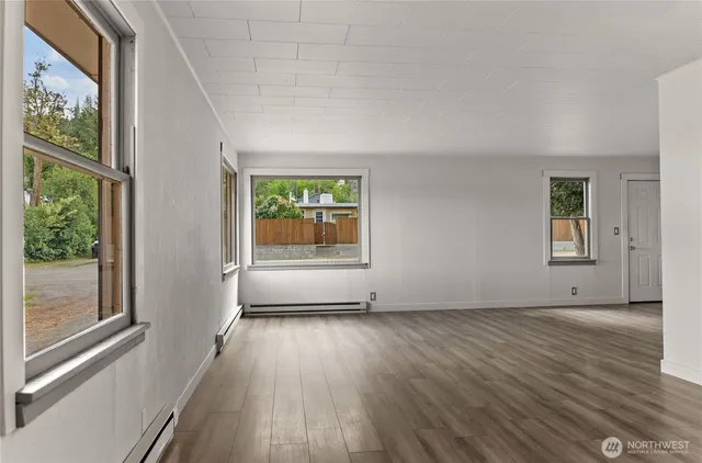 an empty room with windows and wooden floor