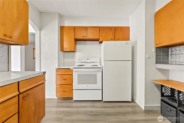 a white refrigerator freezer and a stove sitting inside of a kitchen