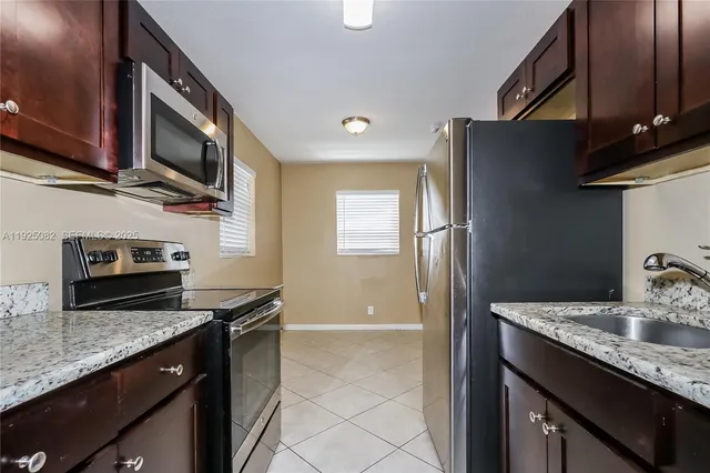 a kitchen with granite countertop stainless steel appliances and wooden cabinets