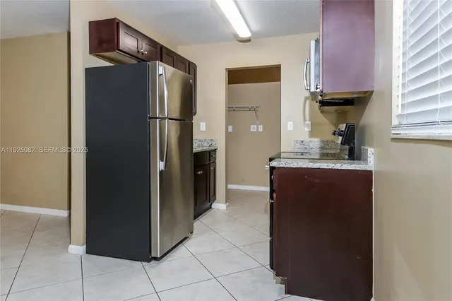 a kitchen with refrigerator and cabinets