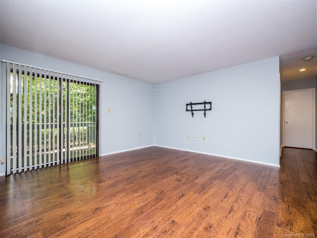 4918 Sardis Road, Unit A Charlotte, NC 28270 - Photo 3 of 19 an empty room with wooden floor and windows