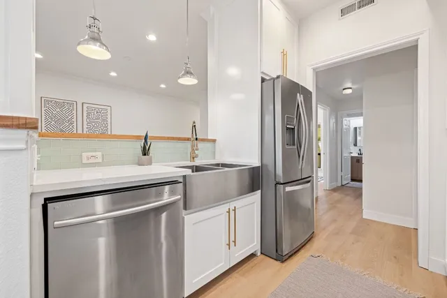 a kitchen with stainless steel appliances granite countertop a refrigerator and a sink