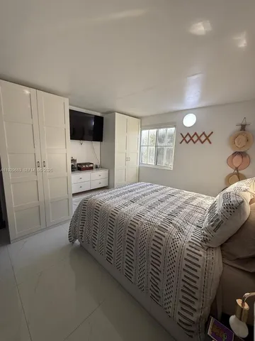 a bedroom with a large bed and a flat tv screen