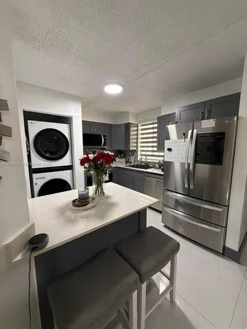 a kitchen with a table chairs and a refrigerator