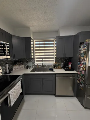 a kitchen with stainless steel appliances granite countertop a sink and a stove