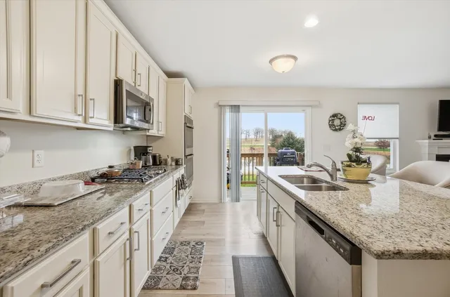 a kitchen with stainless steel appliances granite countertop a sink stove and cabinets