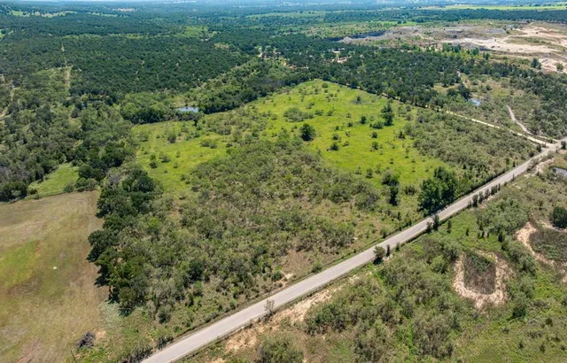 a view of a green yard with large trees