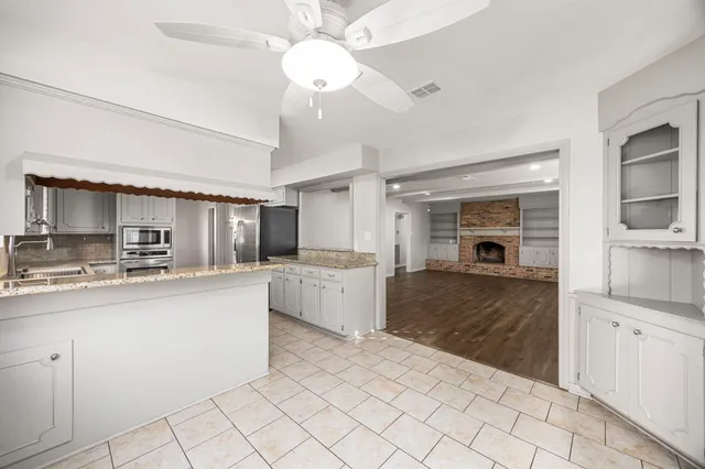 a large kitchen with cabinets a sink and a stove